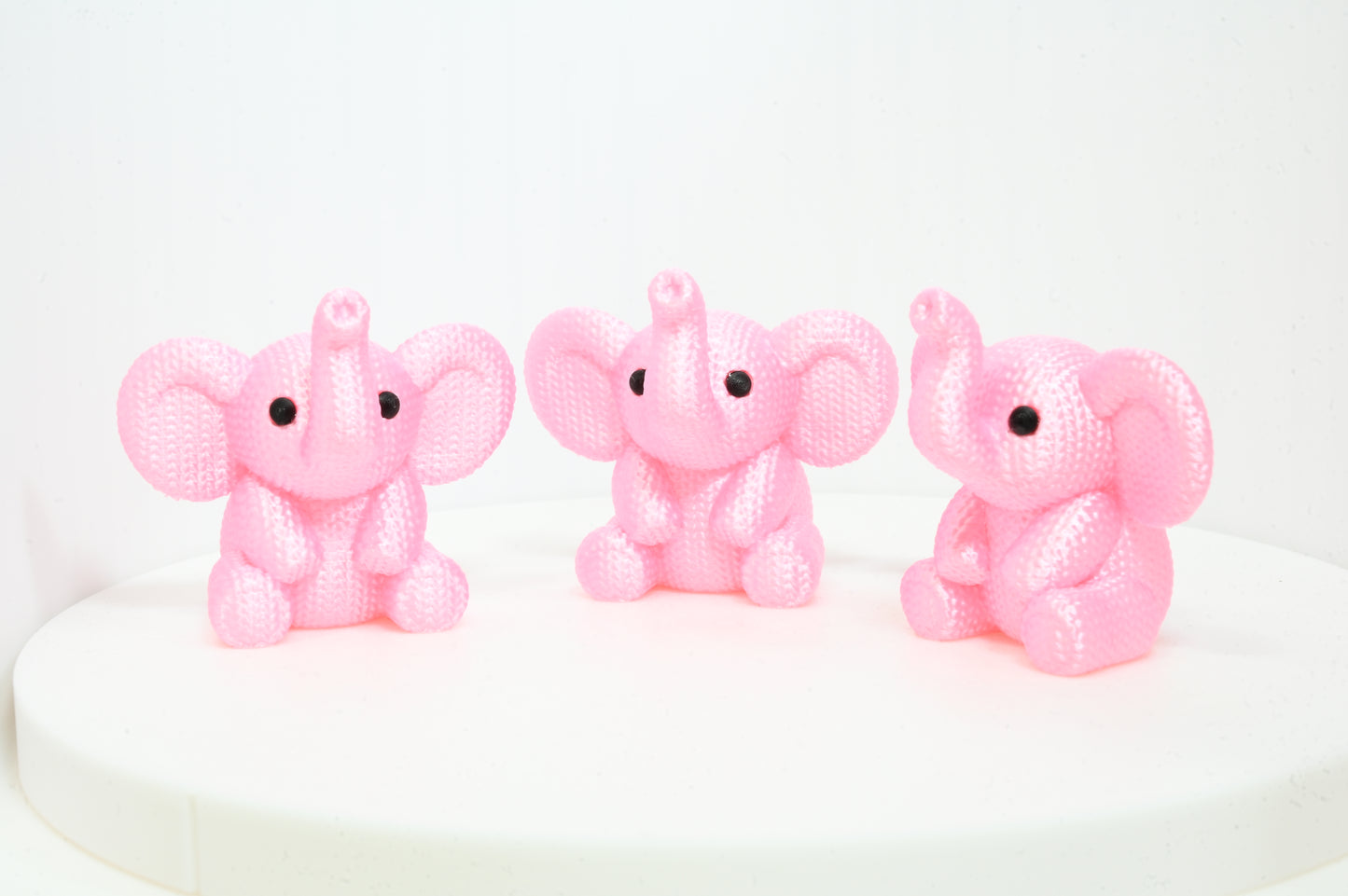 Super cute knitted style elephant with trunk in the air