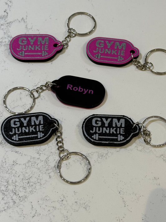 Gym Junkie keychains on a textured surface