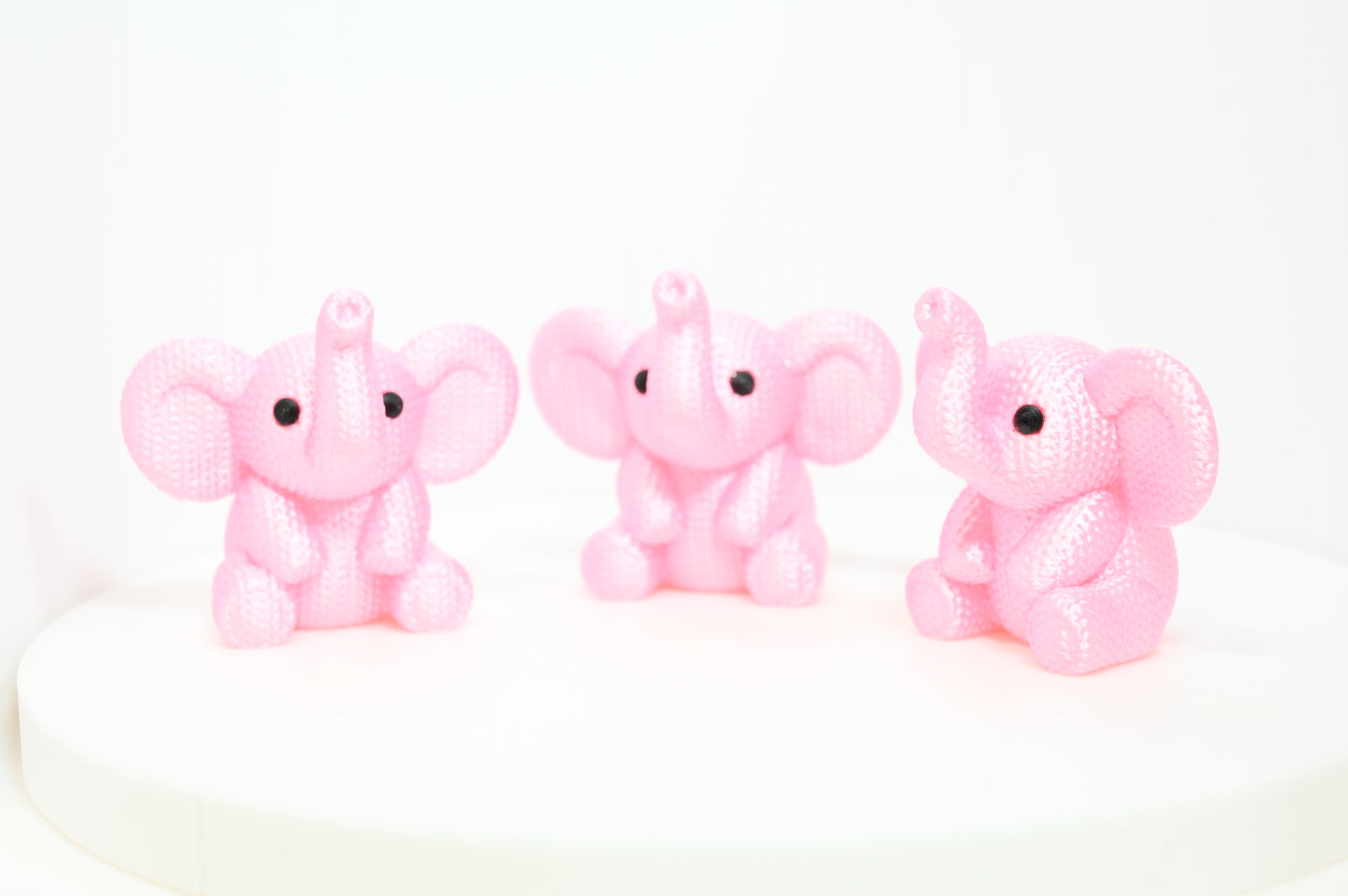 Super cute knitted style elephant with trunk in the air