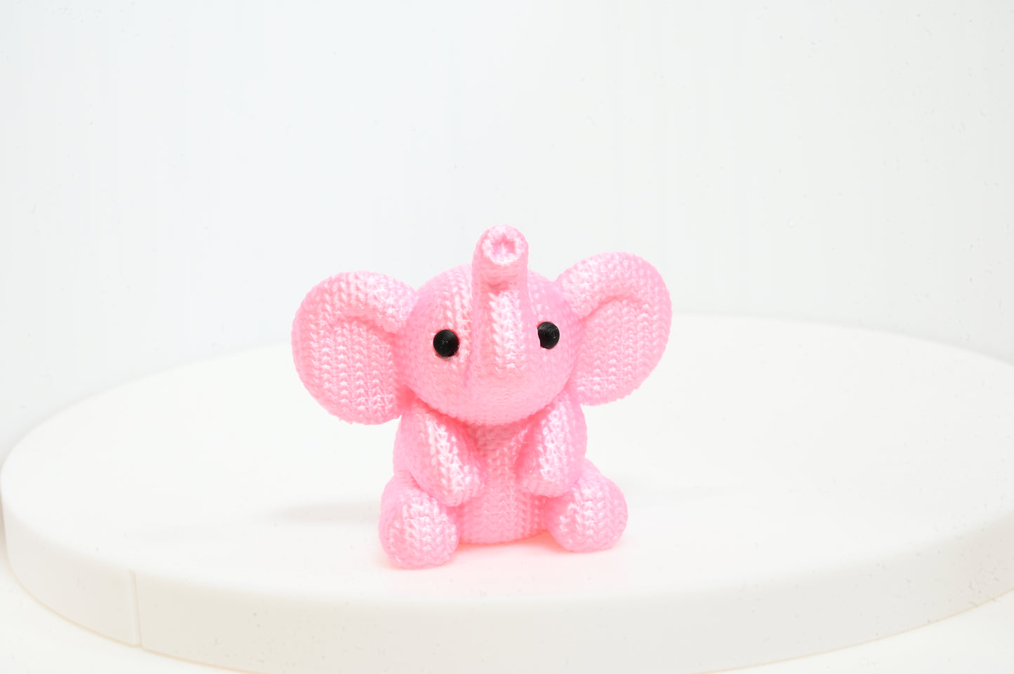 Super cute knitted style elephant with trunk in the air