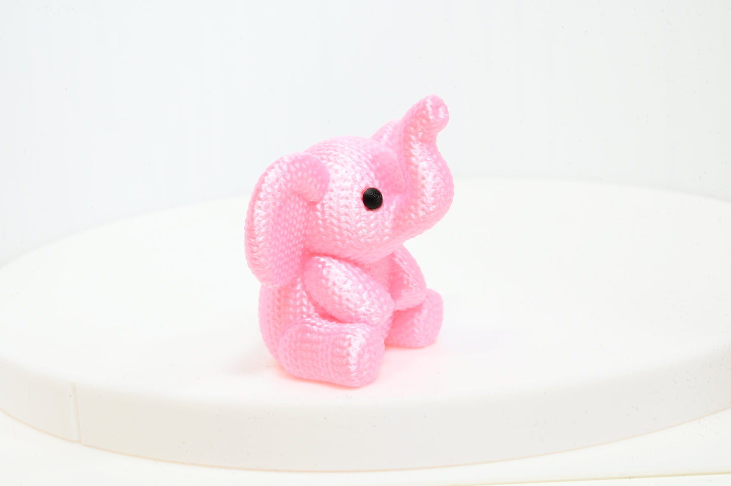 Super cute knitted style elephant with trunk in the air