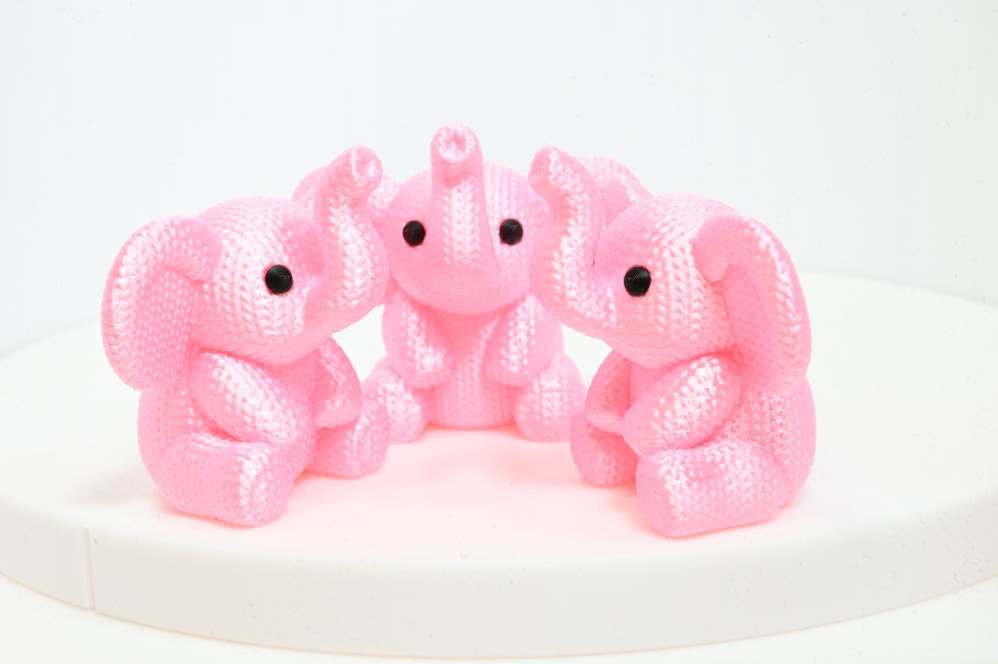 Super cute knitted style elephant with trunk in the air